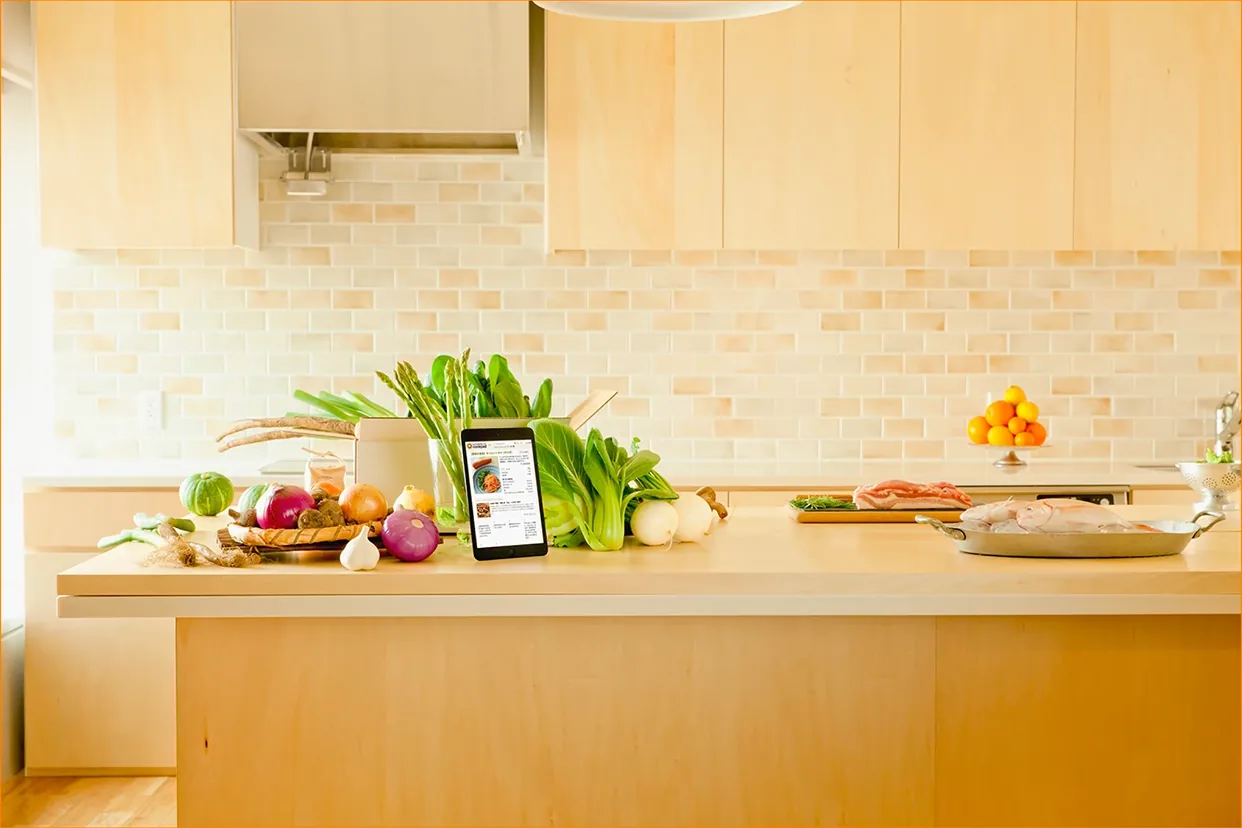 Key visual: vegetables and a tablet on a kitchen counter